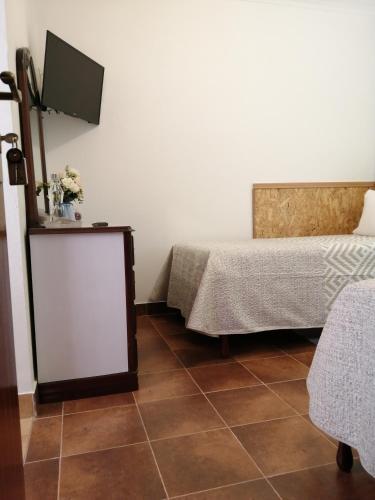 a room with two beds and a flat screen tv at Casa Vaz 2 in Grândola