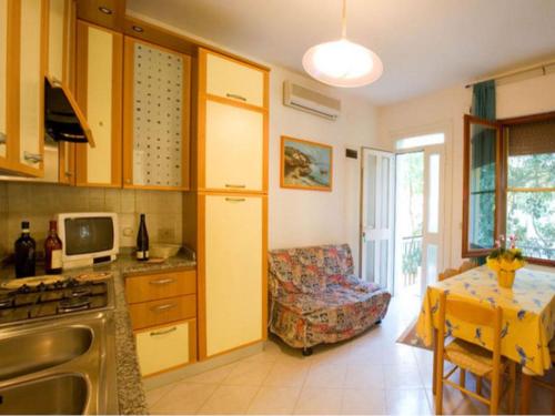 a kitchen with a table and a couch in a room at Homely apartment close to the beach - Beahost in Rosolina Mare