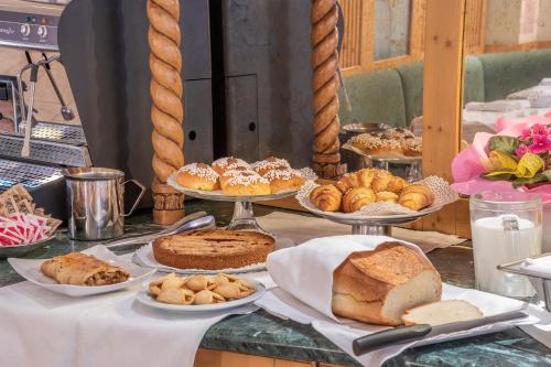 a table with different types of bread and pastries at Hotel Relais Orsingher in Fiera di Primiero