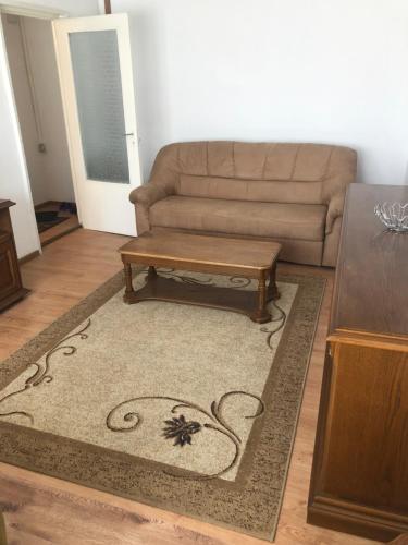 a living room with a couch and a coffee table at Apartament 1 comera in Lugoj