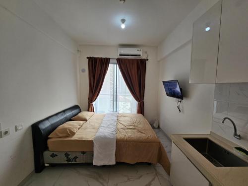 a small bedroom with a bed and a window at Apartement Sky House BSD By LiviRooms in Tjilandak