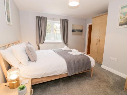 a bedroom with a large bed and a window at Haul a Gwynt in Holyhead