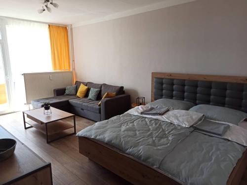 sala de estar con cama y sofá en Áron Apartman Pécs, en Pécs