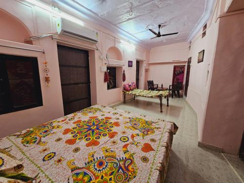 a bedroom with a bed with a colorful bedspread at Haveli Gulabram Ji, Bundi in Būndi