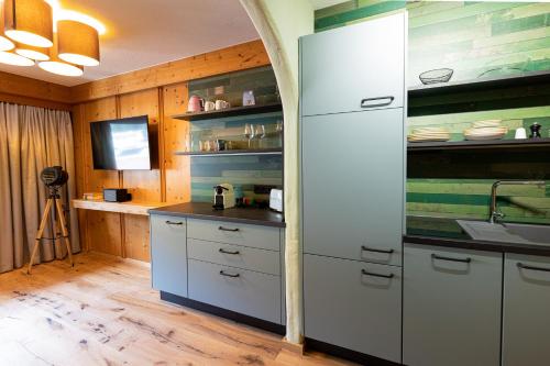 a kitchen with a white refrigerator and a sink at Wellness Aparthotel "Lechlife" incl Pool - 400m zum LIFT in Reutte