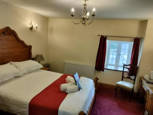 a bedroom with a bed with a laptop on it at Great Trethew Hotel - Self Catering Lodges - Bar & Restaurant in Liskeard