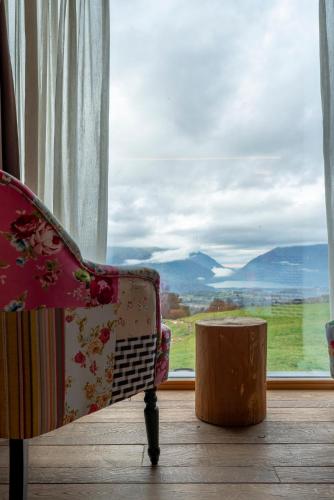 a chair sitting in front of a large window at Casera Cornolera in Chies dʼAlpago