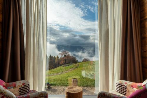 a window with a view of a green hill at Casera Cornolera in Chies dʼAlpago