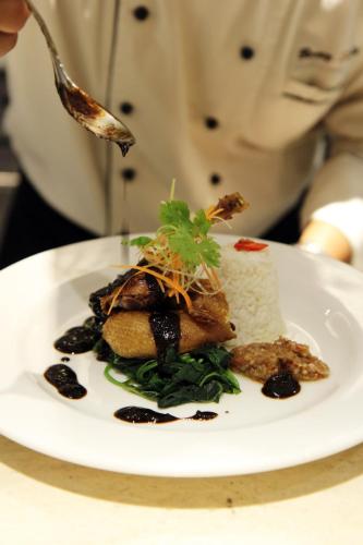 a person eating a plate of food with a spoon at SenS Hotel and Spa in Ubud