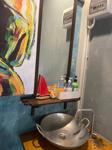 a bathroom with a sink and a painting on the wall at Artist's Place Trat in Trat