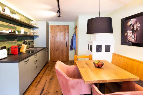 a kitchen with a wooden table and pink chairs at Wellness Aparthotel "Lechlife" incl Pool - 400m zum LIFT in Reutte