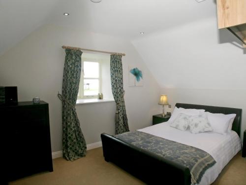 a bedroom with a bed and a window at Wandale Barn in Slingsby