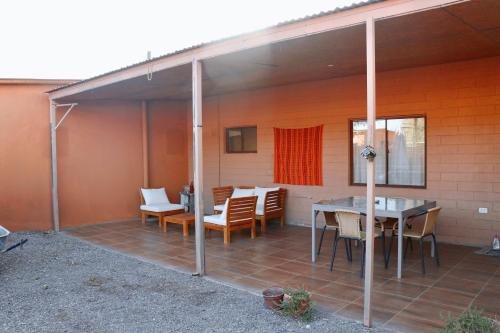 a screened in patio with a table and chairs at Peumayen Atacama cabaña&Hostal in San Pedro de Atacama