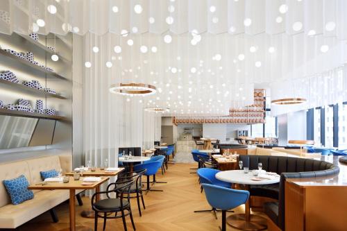 a dining room with tables and blue chairs at W Osaka in Osaka