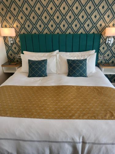 ブラックプールにあるThe Gatsby Blackpool - Formerly The Windsorのベッドルーム1室(緑のヘッドボード付きの大型ベッド1台付)