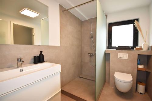 a bathroom with a sink and a toilet and a mirror at SWEET HOME in Meerbusch bei Messe Düsseldorf in Meerbusch