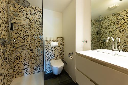 a bathroom with a toilet and a sink and a shower at Wellness Aparthotel "Lechlife" incl Pool - 400m zum LIFT in Reutte