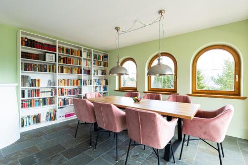 a dining room with a table and pink chairs at Wellness Aparthotel "Lechlife" incl Pool - 400m zum LIFT in Reutte