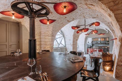 una sala da pranzo con un grande tavolo in legno e bicchieri da vino di Paragon 700 Boutique Hotel & SPA a Ostuni