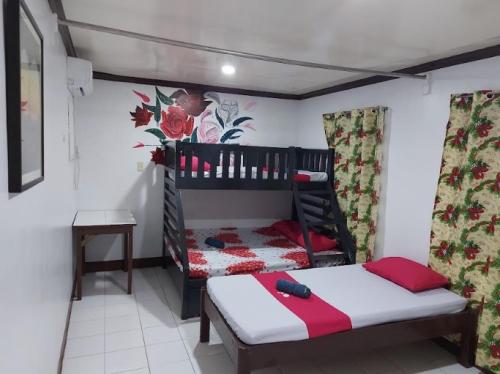 a bedroom with two bunk beds and a table at RedDoorz at Kaffe De Oro Hotel Socorro Oriental Mindoro in Socorro