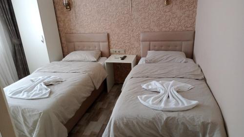 two beds sitting next to each other in a room at Send Apart Otel in Antalya