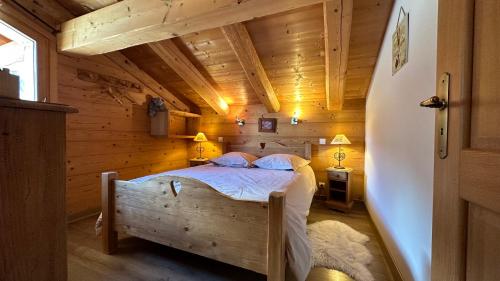 a bedroom with a bed in a wooden cabin at L'ourson in Le Grand-Bornand