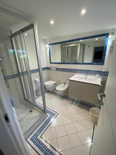 y baño con 2 aseos, lavamanos y ducha. en Attico Fronte Mare nel Borgo di Celle Ligure, en Celle Ligure
