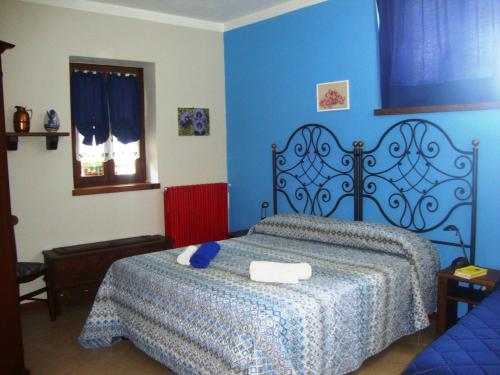 a bedroom with a bed with a blue wall at Bed & Breakfast Barba Bertu in Frassino