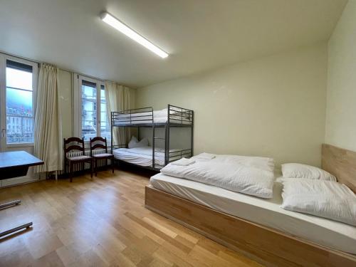 1 dormitorio con 2 camas, mesa y sillas en Happy central apartment, en Interlaken