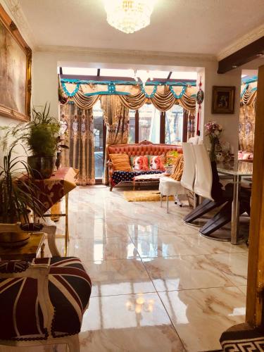 a living room with a couch and a large window at Cheerful 4 bedroom house with garden free parking in London