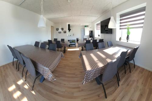 een kamer met tafels en stoelen in een kamer met bij Fælleshuset Kirkebakken in Otterup
