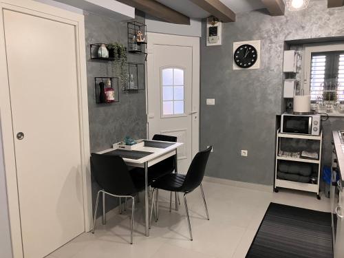 a kitchen with a table and chairs in a room at Studio "MOL" in Baška