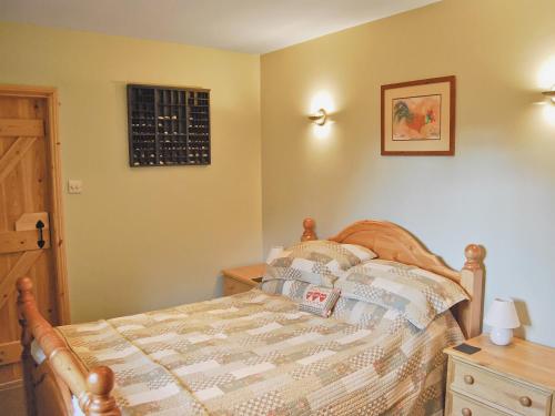 a bedroom with a bed and a dresser and a window at Featherstone Cottage in Pickering