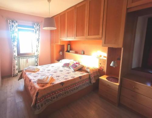1 dormitorio con 1 cama, ventana y armarios en Historic family house en Montefiascone