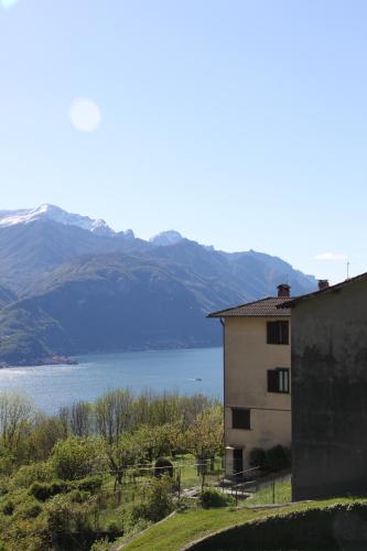 a building on a hill next to a body of water at Hotel Ristorante La Sorgente in Plesio