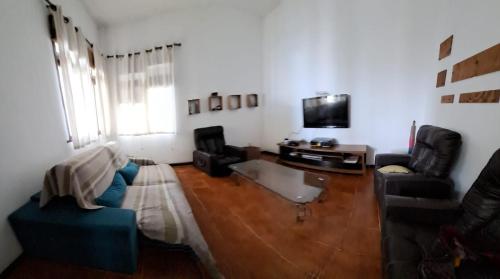 uma sala de estar com um sofá e uma televisão em Mansão Rústica na Joatinga Piscina Fundo Infinito no Rio de Janeiro