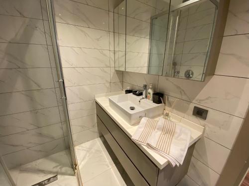 La salle de bains blanche est pourvue d'un lavabo et d'un miroir. dans l'établissement Merkezi ve huzurlu, à Istanbul