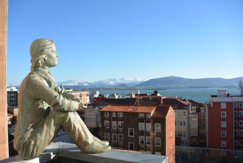 a statue of a man sitting on top of a building at Hotel Art Santander in Santander