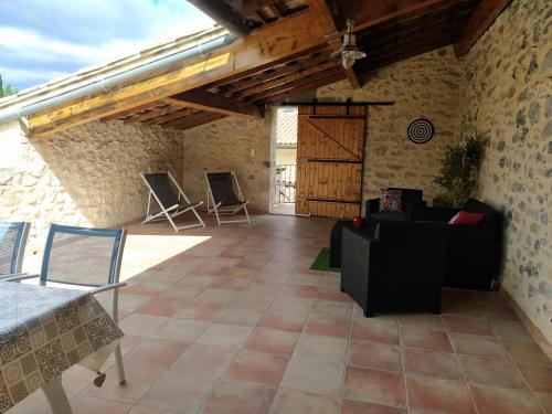 - un salon avec un canapé et des chaises sur une terrasse dans l'établissement Charmante bastide à Vallon Pont d'Arc, à Vallon-Pont-dʼArc