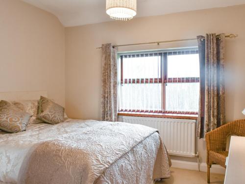 a bedroom with a bed and a window at North Cottage in Heighington