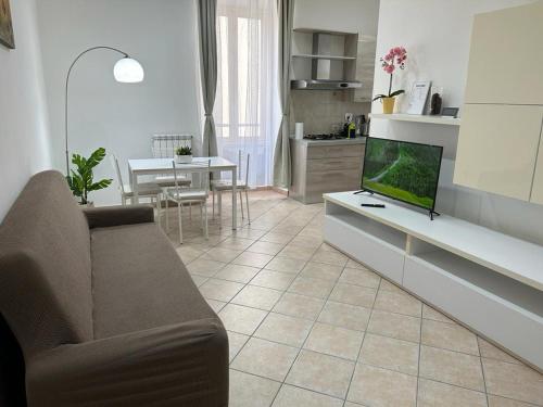 ein Wohnzimmer mit einem Sofa und einem Tisch mit einem TV in der Unterkunft Appartamenti Doria in Civitavecchia