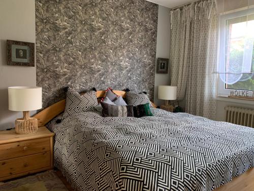a bedroom with a bed with a black and white comforter at Ferienwohnung Zur Heide in Rheine