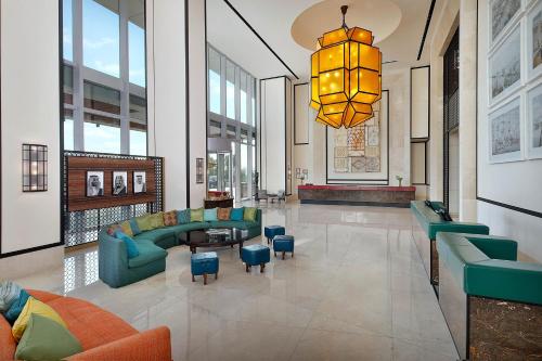 un hall d'entrée avec un canapé, des chaises et un lustre dans l'établissement Assila, a Luxury Collection Hotel, Apartment Jeddah, à Djeddah