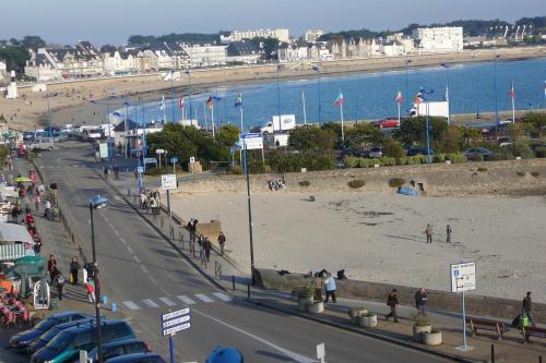 - une vue sur une plage avec des voitures garées sur la route dans l'établissement Appartement port maria vue mer, à Quiberon