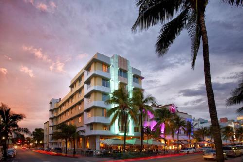 a building with palm trees in front of a street at Winter Haven, Autograph Collection in Miami Beach