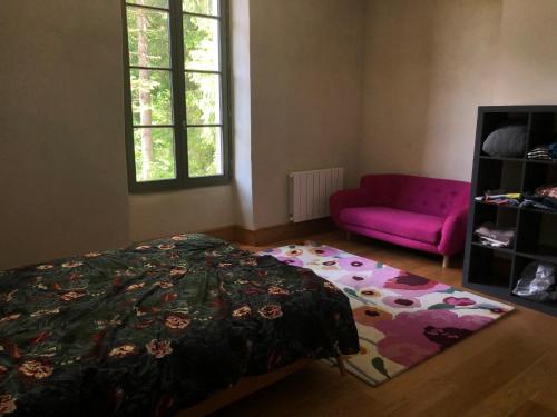 - une chambre avec un lit et un canapé rose dans l'établissement Le Lodge Saissac, à Saissac