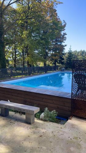 - une piscine avec un banc à côté d'une clôture dans l'établissement Le Lodge Saissac, à Saissac