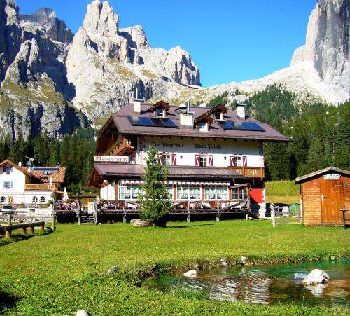 a large building in front of a mountain at Rifugio Monti Pallidi in Canazei