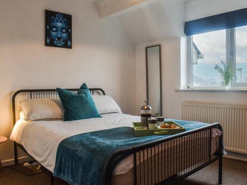 een slaapkamer met een bed met een zwart masker op de muur bij Sunny Dales Townhouse in Settle