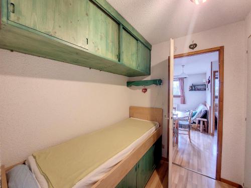 Un pequeño dormitorio con una cama y una puerta a un comedor en Appartement 1 chambre avec garage, en Praz-sur-Arly
